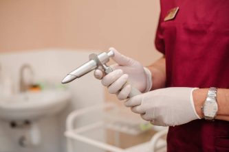 Anoscopes with ring lights in the hands of a doctor